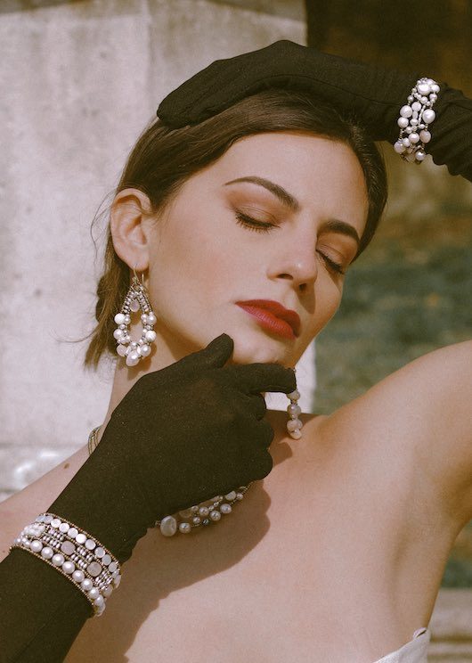 A beautiful women with black long gloves in an Italian garden wears stunning Ziio Jewels made of pearls, mother of pearls form the collection called Shinju. Shinju means Pearl in Japanese