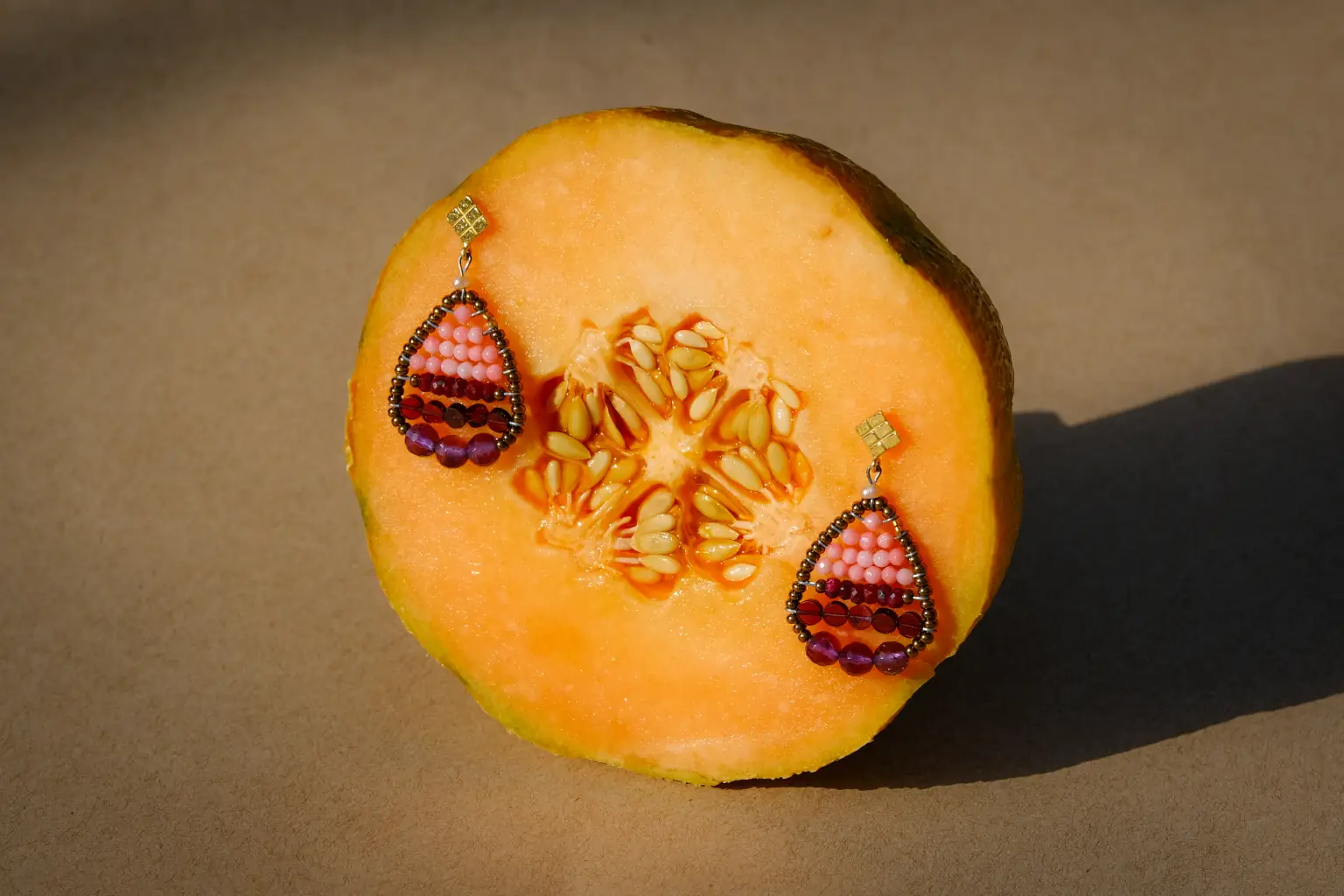 Jardin Red earrings arranged on a melon
